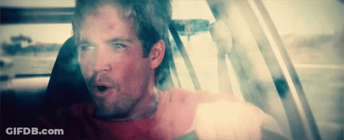 A Man In A Red Shirt Is Sitting In A Car With His Mouth Open GIF