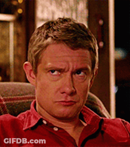 A Man In A Red Shirt Is Sitting In A Chair GIF