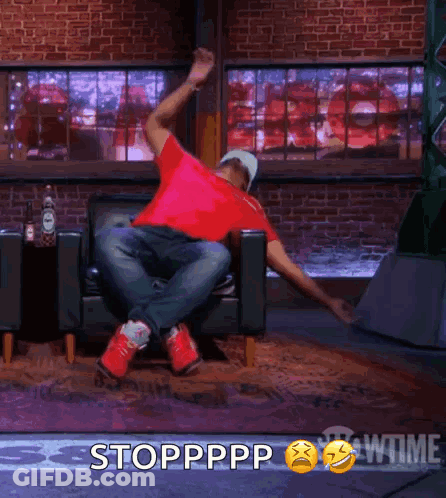 A Man In A Red Shirt Is Sitting In A Chair With His Arms Outstretched And The Words Stoppppp Behind Him GIF