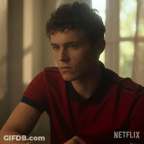 A Man In A Red Shirt Is Sitting In Front Of A Window With A Netflix Logo Behind Him GIF
