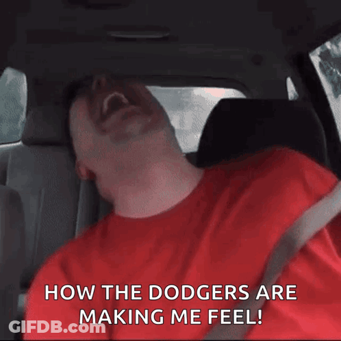 A Man In A Red Shirt Is Sitting In The Back Seat Of A Car And Laughing GIF