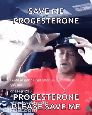 A Man In A Red Shirt Is Sitting In The Driver 'S Seat Of A Car And Holding His Head . GIF
