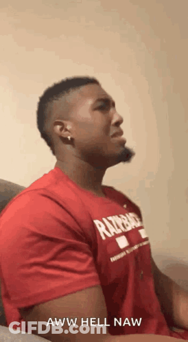 A Man In A Red Shirt Is Sitting On A Couch And Says Aww Hell Naw . GIF