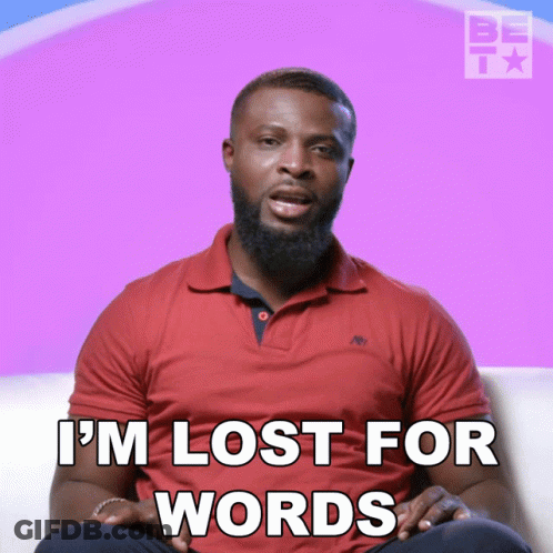 A Man In A Red Shirt Is Sitting On A Couch And Says I 'M Lost For Words GIF