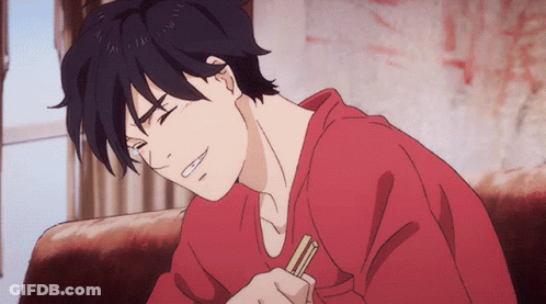 A Man In A Red Shirt Is Sitting On A Couch Holding Chopsticks GIF