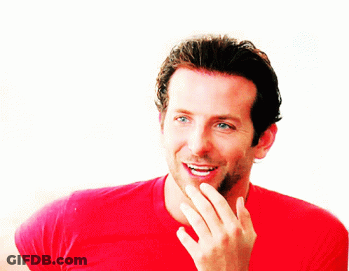 A Man In A Red Shirt Is Smiling And Covering His Mouth GIF
