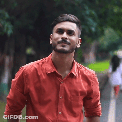 A Man In A Red Shirt Is Smiling And Looking Up GIF