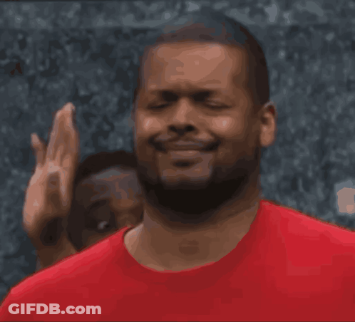 A Man In A Red Shirt Is Smiling And Making A Face GIF