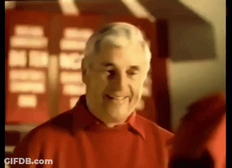 A Man In A Red Shirt Is Smiling In A Blurry Photo GIF