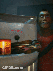 A Man In A Red Shirt Is Smiling In Front Of A Fridge GIF