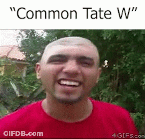 A Man In A Red Shirt Is Smiling With The Words `` Common Tate W '' Written Above Him . GIF