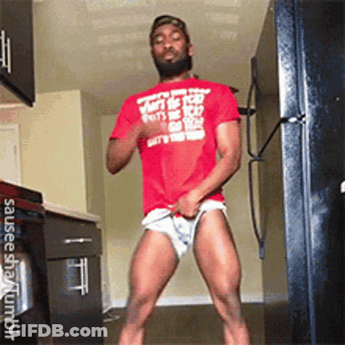 A Man In A Red Shirt Is Standing In A Kitchen With His Pants Down . GIF