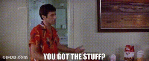 A Man In A Red Shirt Is Standing In A Room Talking To Another Man . GIF
