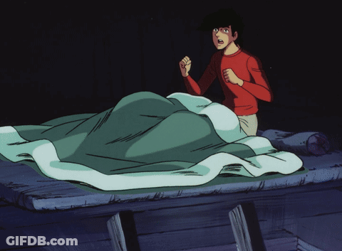 A Man In A Red Shirt Is Standing In Front Of A Bed GIF