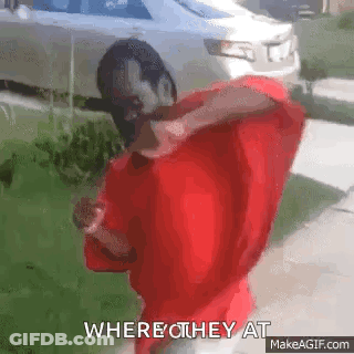 A Man In A Red Shirt Is Standing In Front Of A Car And Says Where They At . GIF