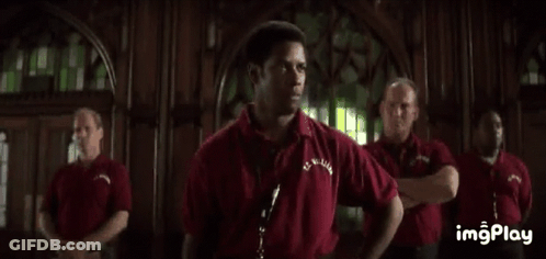 A Man In A Red Shirt Is Standing In Front Of A Group Of Men And Says `` We Will Be Perfect ... '' . GIF