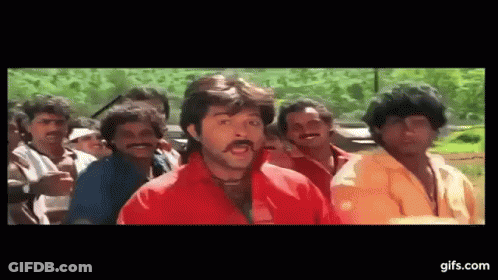 A Man In A Red Shirt Is Standing In Front Of A Group Of Men . GIF