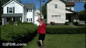 A Man In A Red Shirt Is Standing In Front Of A House With Senorgif.com In The Corner GIF