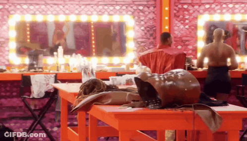 A Man In A Red Shirt Is Standing In Front Of A Mirror GIF