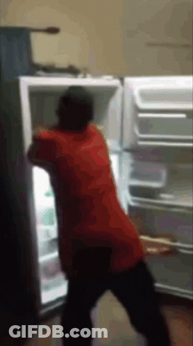 A Man In A Red Shirt Is Standing In Front Of A Refrigerator GIF