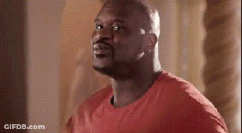 A Man In A Red Shirt Is Standing In Front Of A Wall GIF