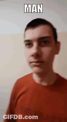 A Man In A Red Shirt Is Standing In Front Of A Wall With The Word Man Above His Head GIF