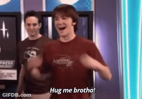 A Man In A Red Shirt Is Standing In Front Of Two Other Men And Says `` Hug Me Brotha '' . GIF