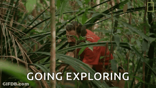 A Man In A Red Shirt Is Standing In The Jungle With The Words `` Going Exploring '' Written Above Him . GIF