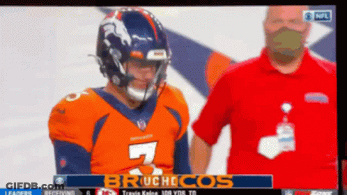 A Man In A Red Shirt Is Standing Next To A Football Player With The Number 7 On His Jersey GIF