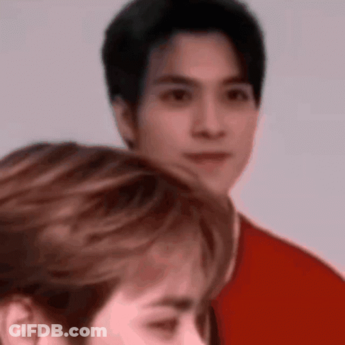 A Man In A Red Shirt Is Standing Next To A Woman In A Red Shirt . GIF