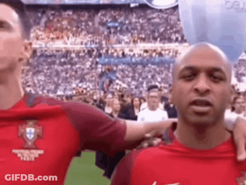 A Man In A Red Shirt Is Standing Next To Another Man In A Red Shirt . GIF