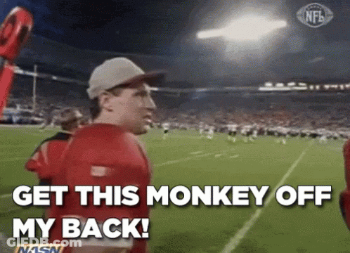 A Man In A Red Shirt Is Standing On A Football Field And Says `` Get This Monkey Off My Back '' . GIF