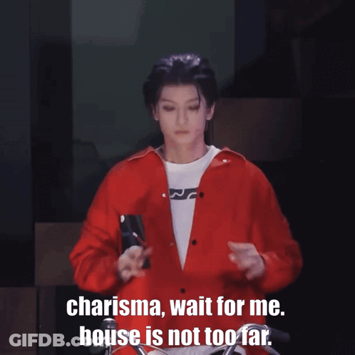 A Man In A Red Shirt Is Standing With His Arms Outstretched And Says " Charisma Wait For Me House Is Not Too Far " GIF