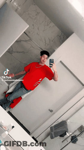 A Man In A Red Shirt Is Taking A Picture Of Himself GIF