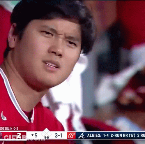 A Man In A Red Shirt Is Watching A Baseball Game GIF