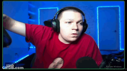 A Man In A Red Shirt Is Wearing Headphones And A Microphone . GIF