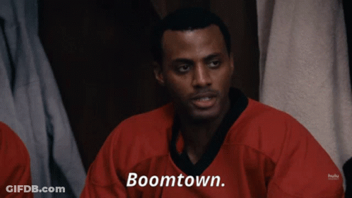 A Man In A Red Shirt Says Boomtown On The Screen GIF