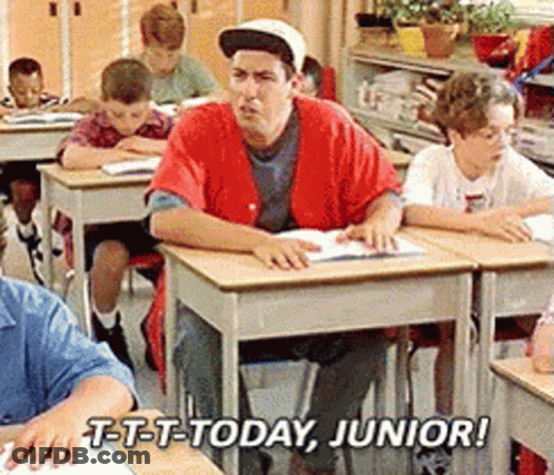 A Man In A Red Shirt Sits At A Desk In A Classroom With The Words T-T-T-Today Junior GIF