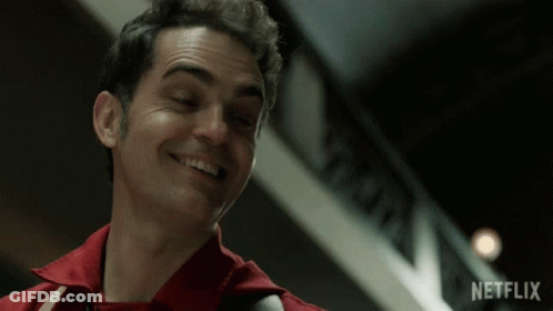 A Man In A Red Shirt Smiles In Front Of A Netflix Logo GIF