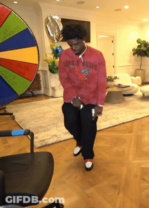 A Man In A Red Shirt That Says Guns N Roses Is Dancing GIF