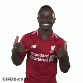 A Man In A Red Shirt That Says Standard Chartered On It GIF