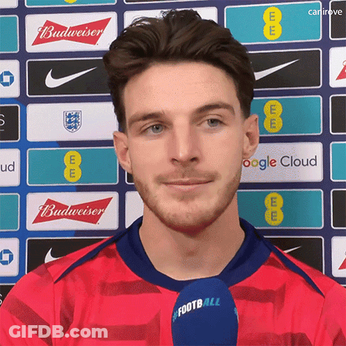 A Man In A Red Shirt With A Microphone That Says Football On It GIF