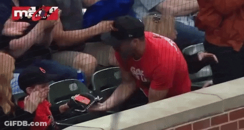 A Man In A Red Shirt With The Letter G On It Is Sitting In A Stadium GIF