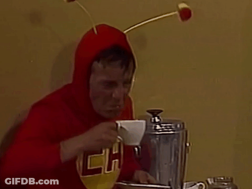 A Man In A Red Shirt With The Letter P On It Drinking A Cup Of Coffee GIF