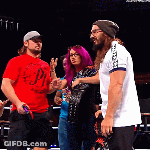 A Man In A Red Shirt With The Letter P On It Talks To A Woman With Purple Hair GIF