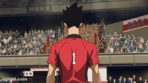 A Man In A Red Shirt With The Number 1 On The Back Stands In Front Of A Crowd GIF