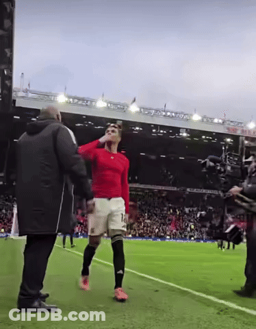 A Man In A Red Shirt With The Number 10 On His Shorts Stands On A Soccer Field GIF