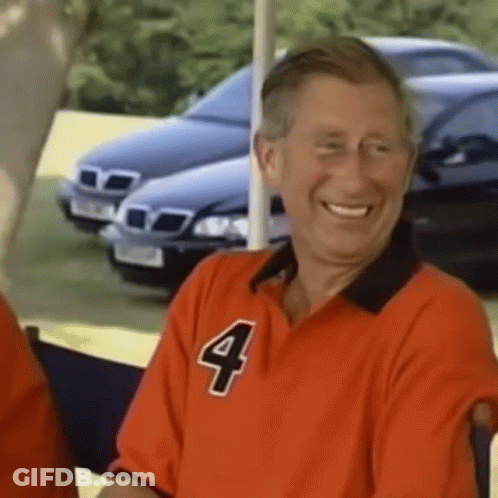 A Man In A Red Shirt With The Number Four On It Is Smiling . GIF