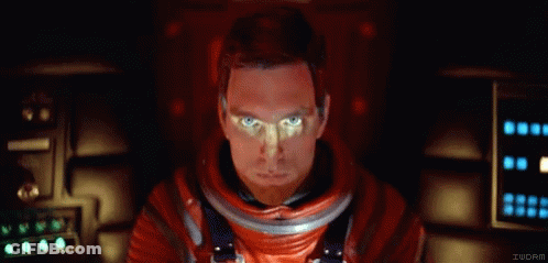 A Man In A Red Space Suit Is Looking At The Camera With The Letters Iucrm Below Him GIF