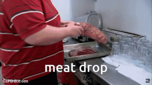 A Man In A Red Striped Shirt Is Holding A Large Piece Of Meat In Front Of A Tray That Says " Meat Drop " GIF